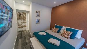 a bedroom with a large bed with blue pillows at Plan Be GuestHouse in Faro