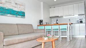 uma sala de estar com um sofá e uma mesa em Apartamentos Gelimar em Puerto Rico de Gran Canaria