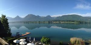 a view of a lake with mountains in the background at Hotel Seehang Garni in St. Wolfgang