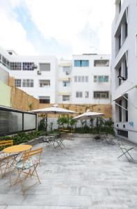 a patio with tables and chairs and umbrellas at Gardenia Boutique Hotel in Rabat
