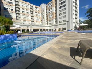 a swimming pool in front of a large building at Flat Park Veredas com Vista Serra com geladeira e fogão in Rio Quente