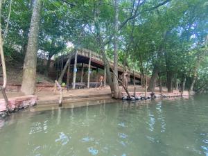 a building next to a body of water with trees at Flat Park Veredas com Vista Serra com geladeira e fogão in Rio Quente