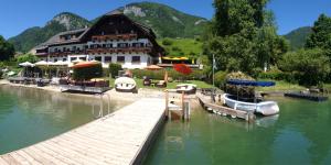 a building with a dock and boats in the water at Hotel Seehang Garni in St. Wolfgang