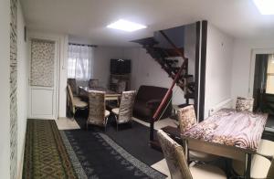 a living room with a table and chairs and a staircase at Casa Savianu Cavnic in Cavnic +6 photos