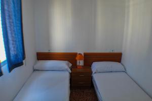 2 letti in una piccola stanza con una lampada tra loro di ANNA 5-A Levante Beach a Benidorm