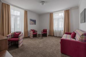 a living room with couches and chairs and windows at Boutique Hotel Societe in Baden-Baden