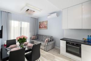 a kitchen and living room with a table and a couch at Angel Apartments 2 in Kraków