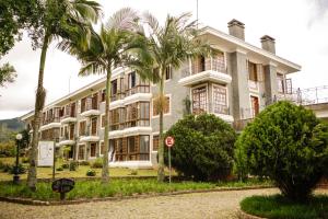 een gebouw met palmbomen ervoor bij Aroso Paço Hotel in Pedra Azul