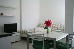 Residence Fanny في ريميني: غرفة معيشة مع طاولة وسرير