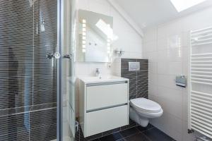 een witte badkamer met een toilet en een wastafel bij Buitenplaats De Mechelerhof in Mechelen