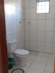 La salle de bains blanche est pourvue de toilettes et d'une fenêtre. dans l'établissement Casa São José da Barra Capitólio, à Elisiário Lemos