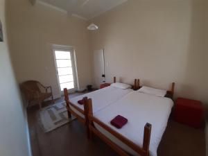 a bedroom with a large white bed and a window at The Owlhouse Backpackers in Nieu-Bethesda
