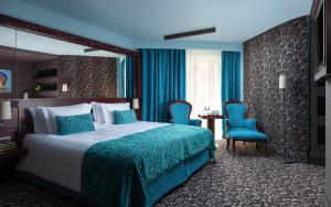 una camera d'albergo con un letto e due sedie blu di Domina St.Petersburg a San Pietroburgo