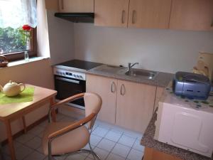 a kitchen with a sink and a table with a chair at Ferienwohnung Mauer in Neuenrade