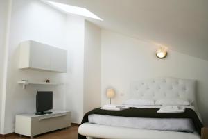 a white bedroom with a bed and a tv at Residence Fanny in Rimini +79 photos