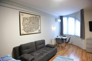 een woonkamer met een bank en een tafel bij Studio Gold apartman in Pécs
