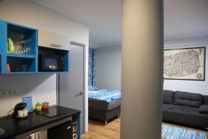a living room with a couch and a bed in a room at Studio Gold apartman in Pécs