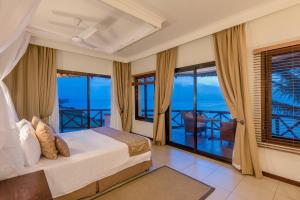 a bedroom with a bed and views of the ocean at Sea Cliff Resort & Spa in Zanzibar City