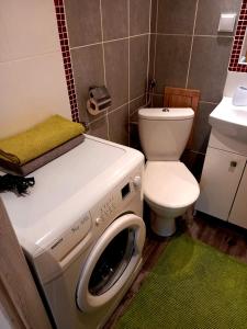 a bathroom with a washing machine and a toilet at Modern Studio 9 in Częstochowa