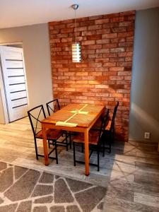 a dining room table with chairs and a brick wall at Modern Studio 9 in Częstochowa