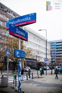 a street sign on a pole in a city at Bello ApartHostel in Warsaw