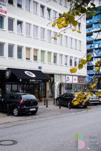 a street with cars parked in front of a building at Bello ApartHostel in Warsaw