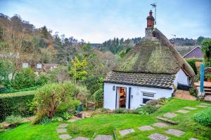 a small white cottage with a thatched roof at Finest Retreats - Little Haven in Minehead
