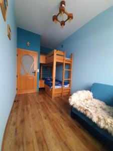 a bedroom with two bunk beds and a blue wall at Apartamenty na Szlaku in Czarny Dunajec