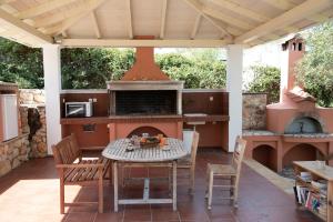 a patio with a table and an outdoor oven at Villa Erato in Tsoukaladhes