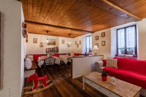 a living room with a red couch and a table at Hotel Signal in Macugnaga