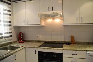 a kitchen with white cabinets and a sink and a stove at Sunny Escape by the Sea & Yacht Club in Altea +13 photos