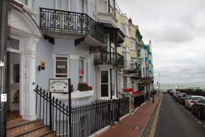 rząd budynków na ulicy z zaparkowanymi samochodami w obiekcie Ambassador Hotel w Brighton and Hove