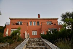 an orange house with stairs in front of it at Villa Erato in Tsoukalades