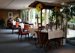 een restaurant met tafels en een paardenkoets bij Hotel Panorama in Einbeck