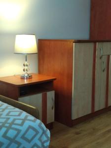 a bedroom with a bed and a table with a lamp at Tęczowy Poranek in Ustrzyki Dolne