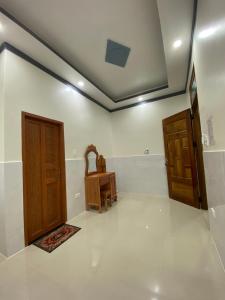 Habitación con 2 puertas de madera y mesa. en Tùng Thủy Homestay - Dinh Thầy Thím Lagi en La Gi