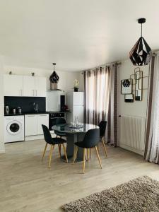 a kitchen and dining room with a table and chairs at St Louis Appartement in Roanne