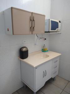 uma cozinha com um lavatório e um micro-ondas em Espaço coração de mãe em Pirapozinho