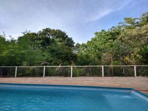 a swimming pool in front of a fence at Recanto do Tião in Itapira