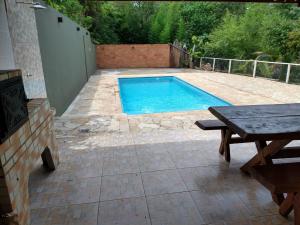 a backyard with a swimming pool and a picnic table at Recanto do Tião in Itapira