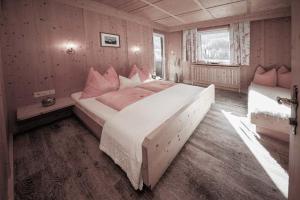 - une chambre avec un grand lit et des oreillers roses dans l'établissement Haus Ingrid, à Sölden