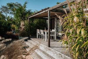 a wooden deck with a table and chairs on it at Le Phare in Les Portes