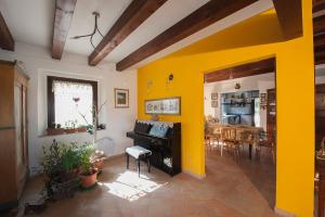 uma sala de estar com paredes amarelas e um piano em B&B Punto Magico em Offagna