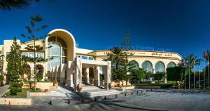 um grande edifício com um banco à frente em Carthage Thalasso Resort em Gammarth