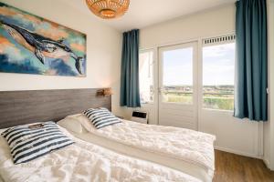 a bedroom with two beds and a window at Appartementencomplex Juliana 176 in De Koog