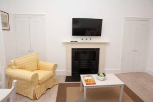 sala de estar con sofá y chimenea en Stunning, 1 Bed Luxury Flat in Central Bath en Bath