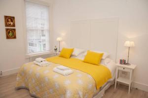 1 dormitorio con 1 cama con sábanas amarillas y almohadas amarillas en Stunning, 1 Bed Luxury Flat in Central Bath, en Bath