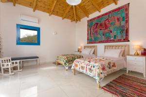 a bedroom with two beds and a painting on the wall at Indigo Villa in Agios Nikolaos +33 photos