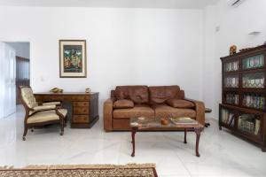 a living room with a brown couch and a chair at Indigo Villa in Agios Nikolaos