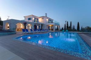 a villa with a swimming pool in front of a house at Indigo Villa in Agios Nikolaos